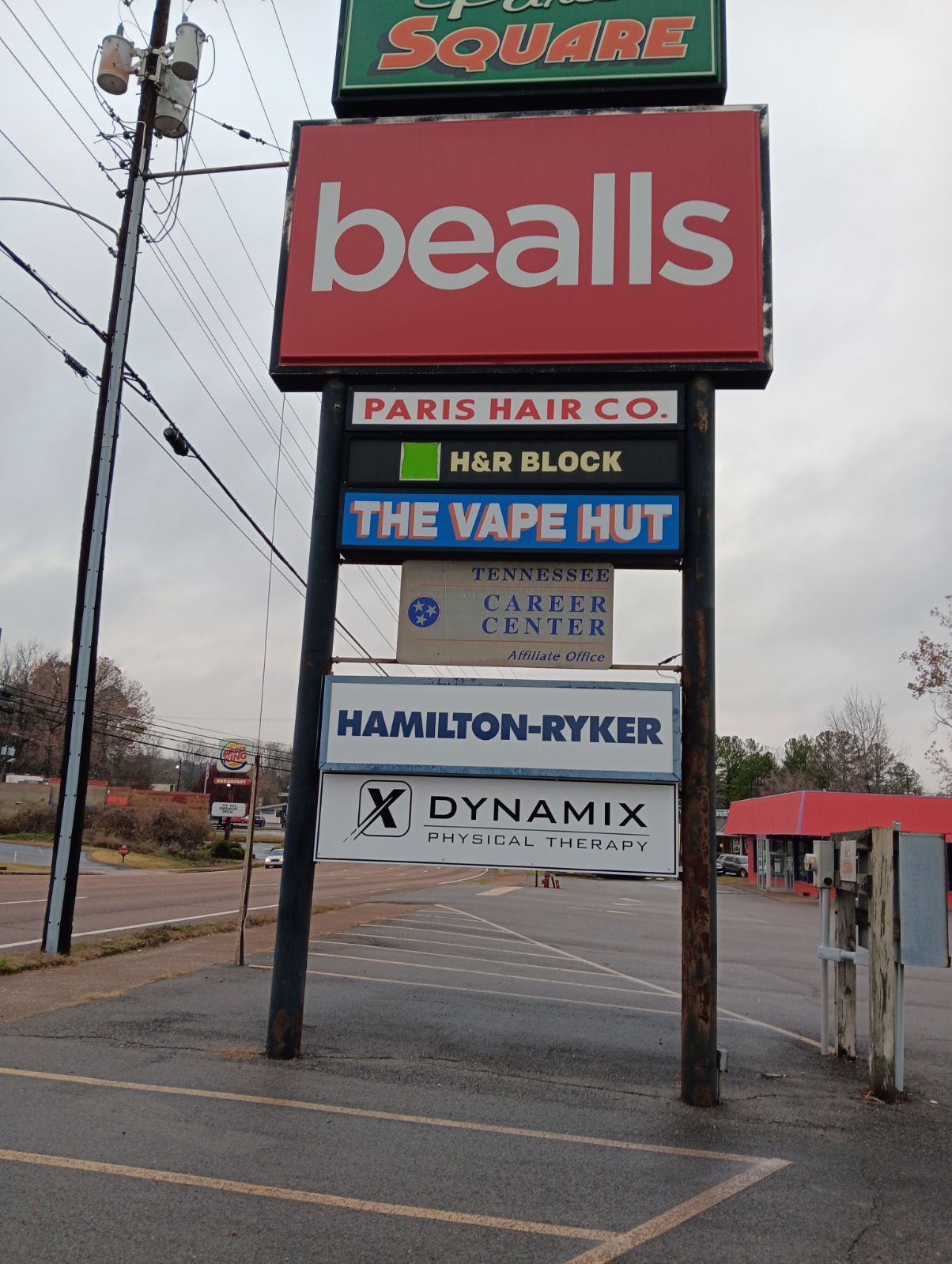 Sign tree at the road with Paris Hair Co