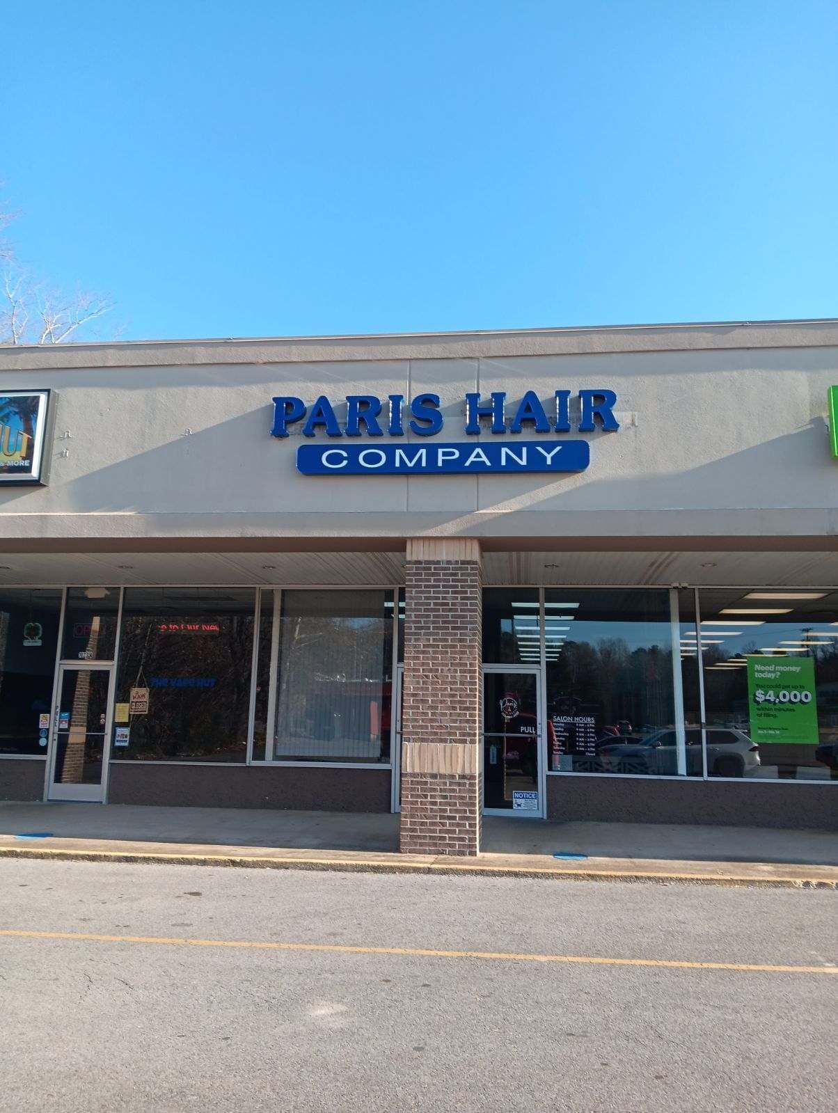 A paris hair company store front with a blue sky in the background