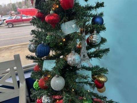 A Christmas tree with a lot of ornaments on it and gift certificates
