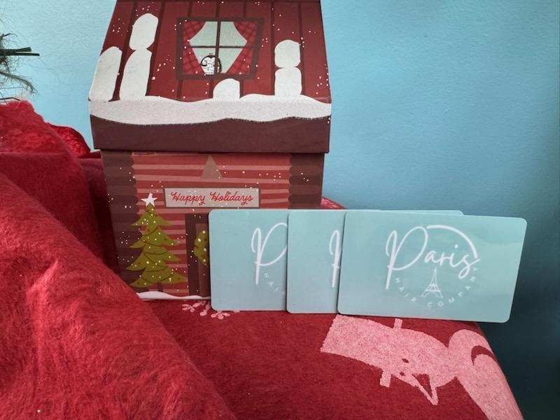 Paris Hair Cut gift certificates beside a Christmas themed display