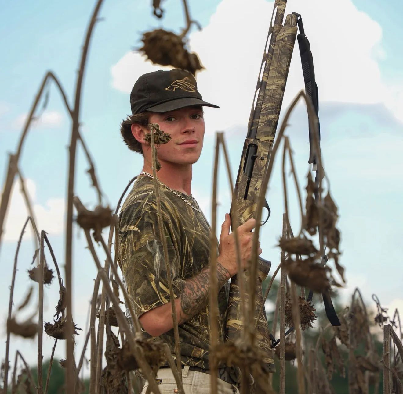 Woman with braided hair and glasses smiles.
