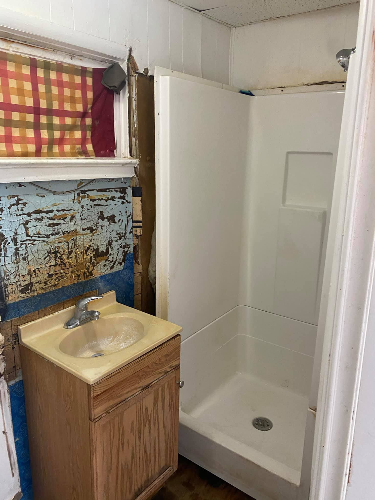 A bathroom with a sink and a shower