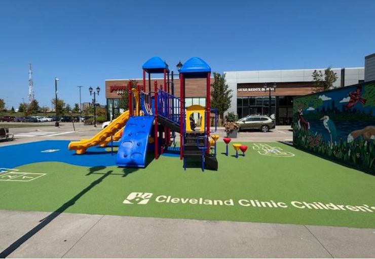 Cleveland Clinic Children’s playground with blue and yellow slides on a green play area