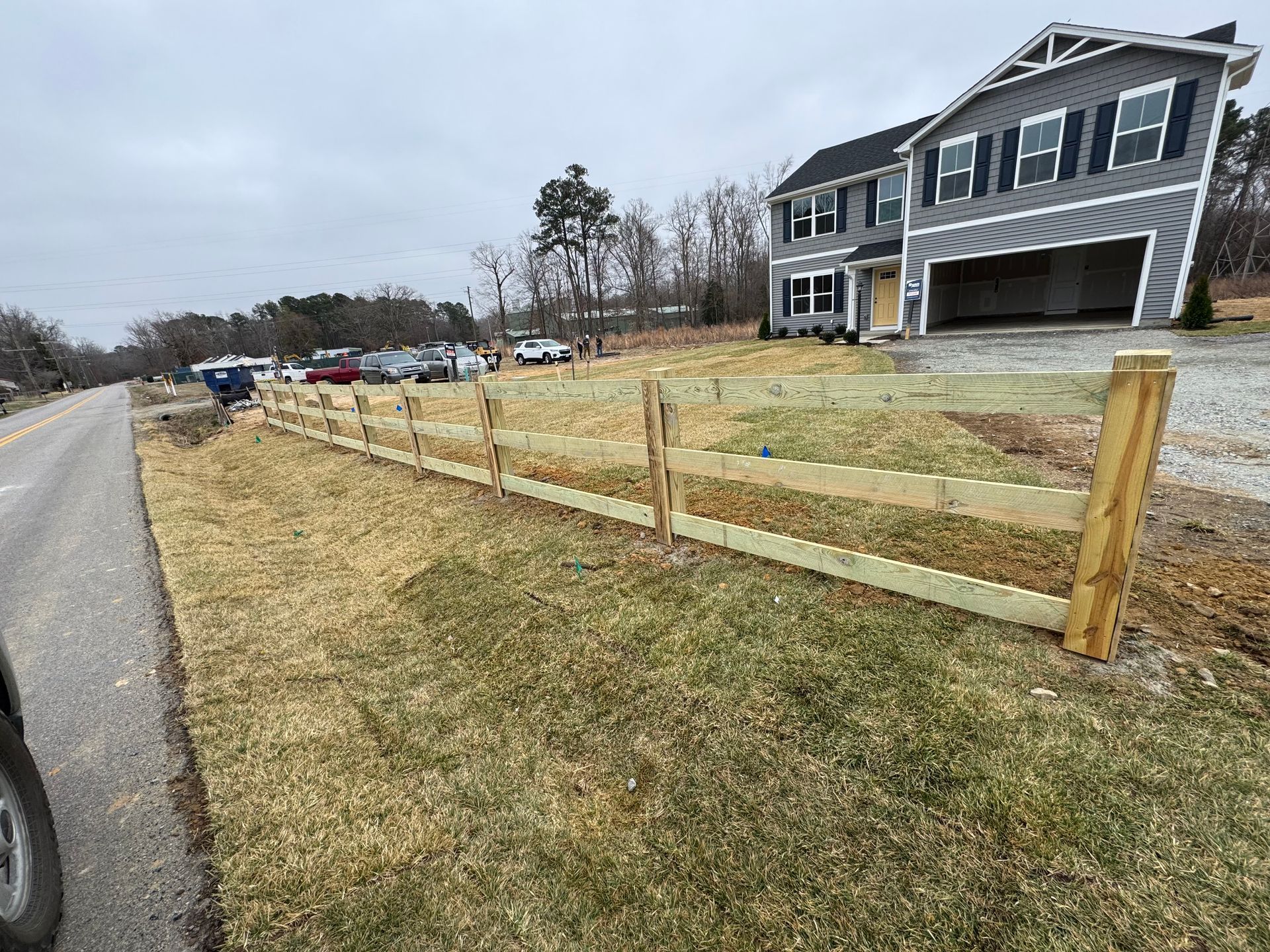 A large house with a wooden fence in front of it.