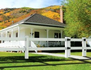 A white house with a white fence in front of it.
