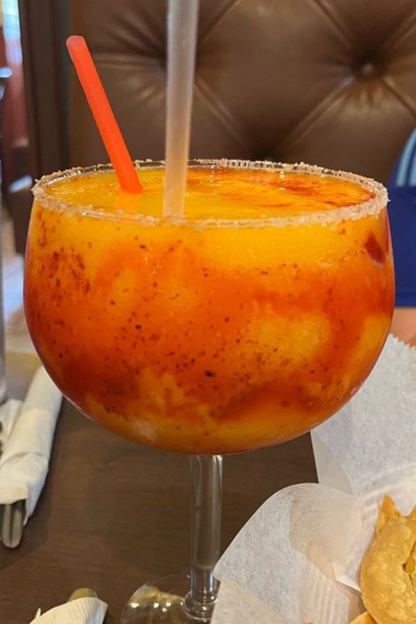 A large margarita with a straw in it