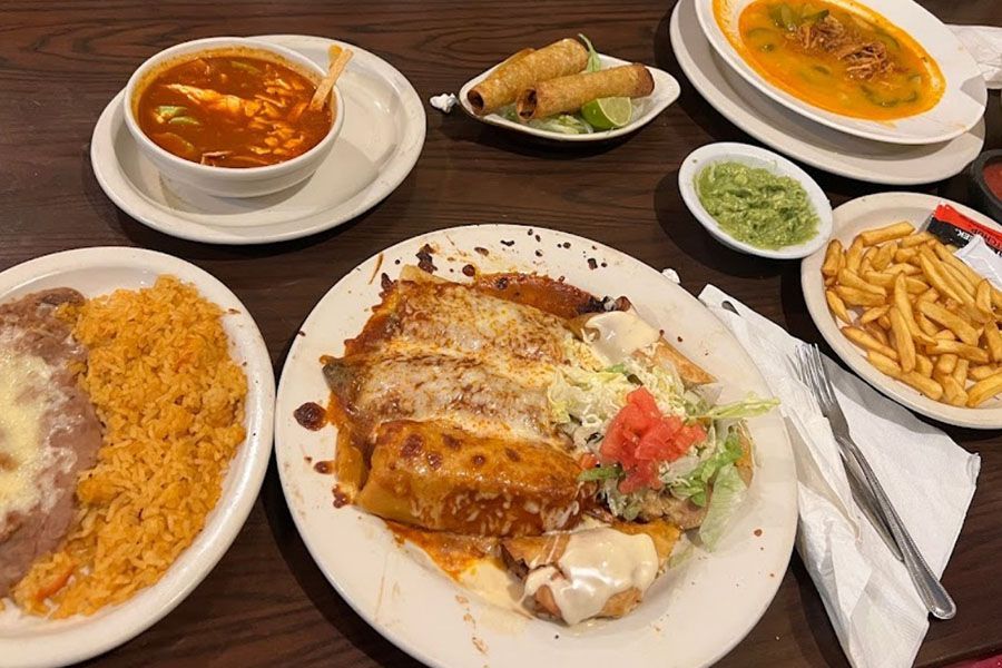 A table topped with plates of food and a bowl of soup.