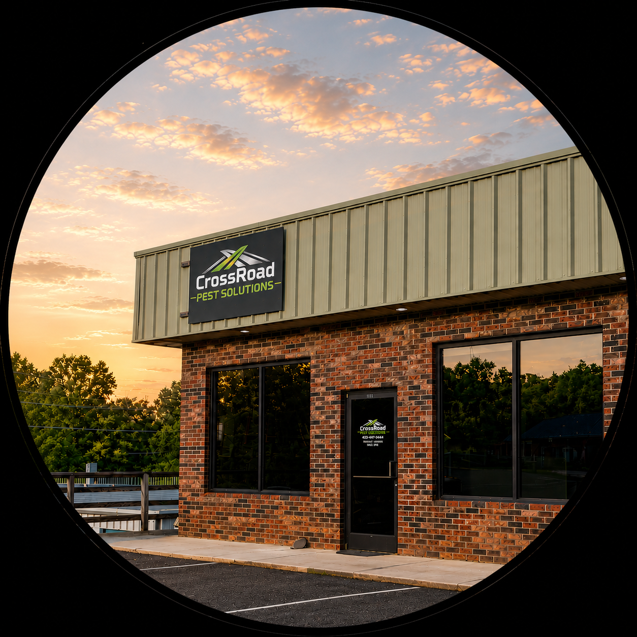 Brick storefront with a CrossRoad sign under a beige roof at sunset, with trees reflected in the windows