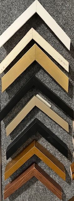 A bunch of different types of picture frames are lined up on a table