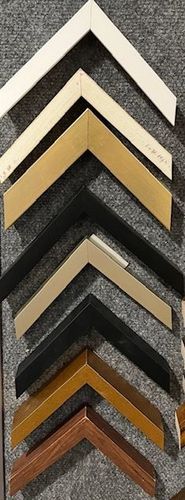 A bunch of different types of picture frames are lined up on a table