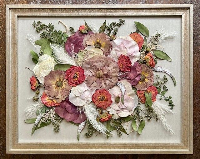 A picture of pink and blue flowers in a wooden frame
