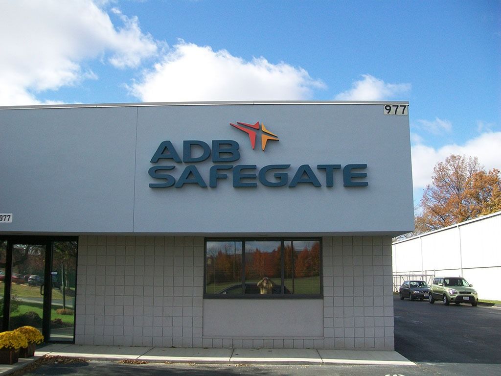 ADB SAFEGATE building with logo and parked cars.