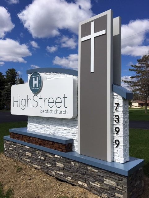 Sign for High Street Baptist Church with cross, address, and logo.