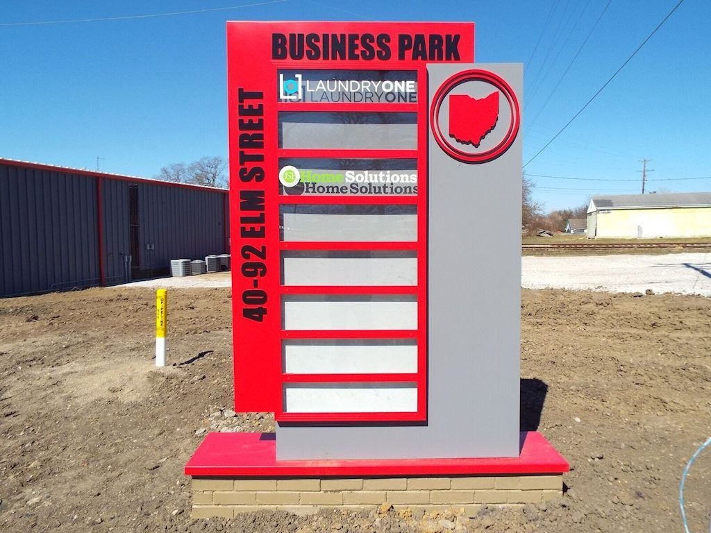 Business park sign, red and grey with tenant logos and Ohio outline, located on 40-92 Elm Street.