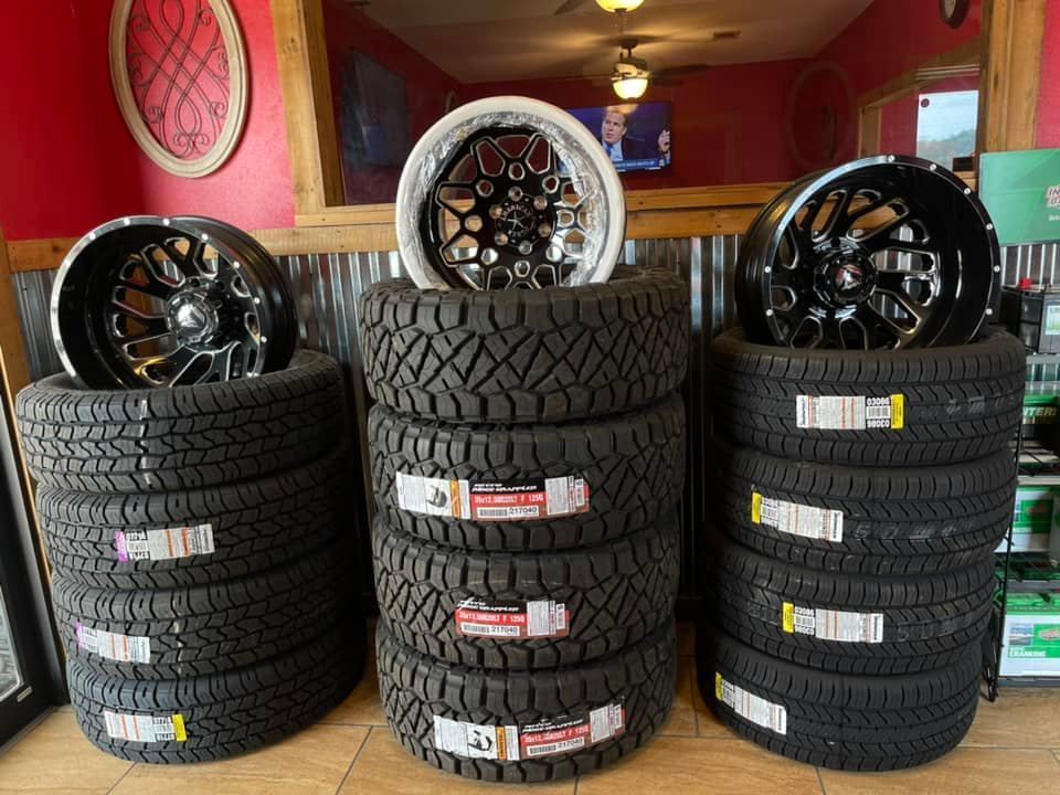 A bunch of tires and wheels are stacked on top of each other