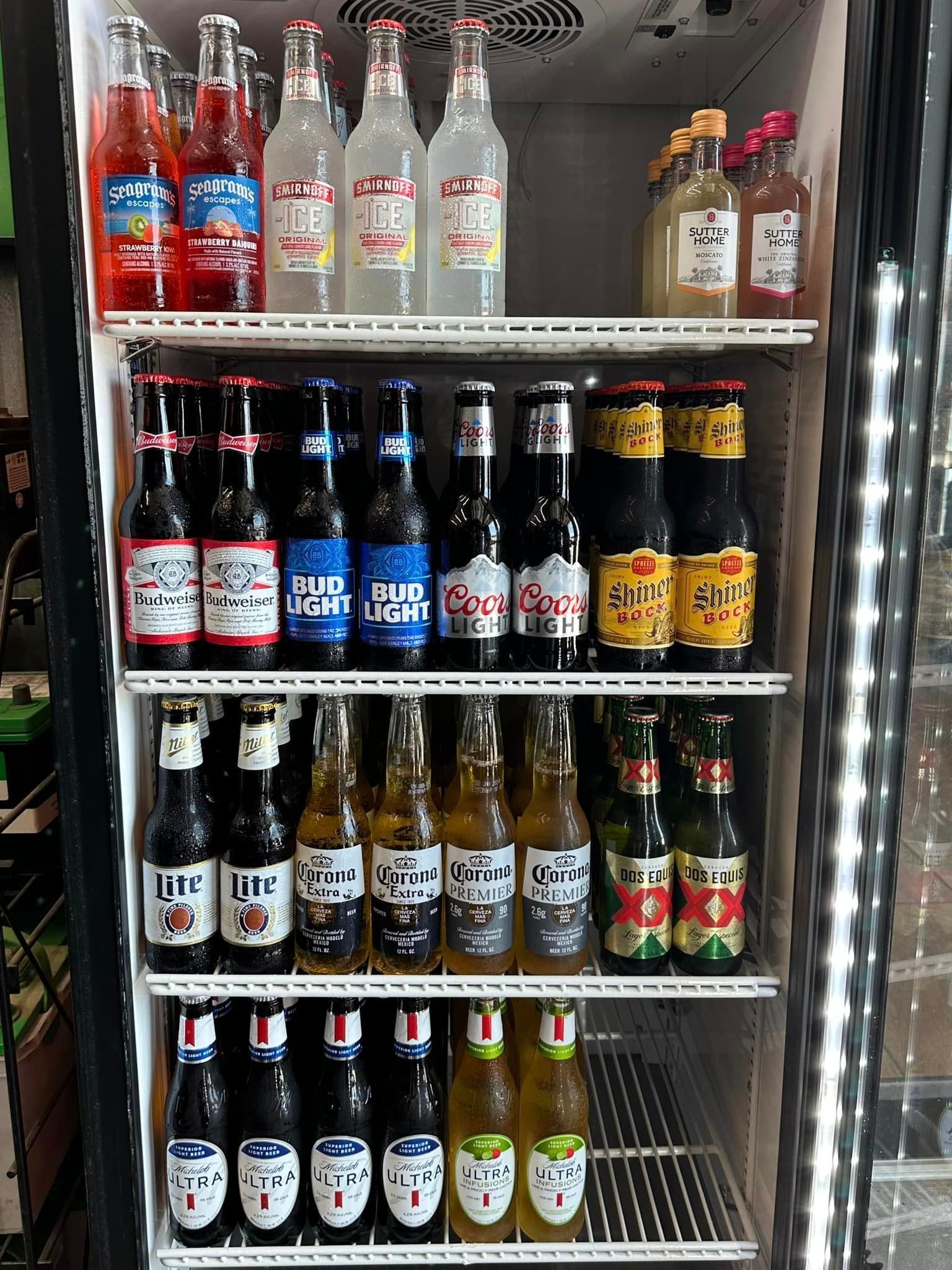 A refrigerator filled with bottles of soda and beer