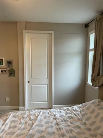 A bedroom with a bed and a white door.