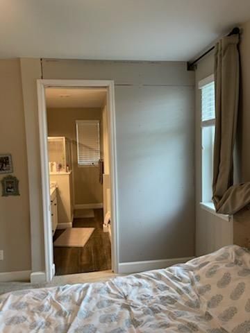 A bedroom with a bed and a door leading to a bathroom.