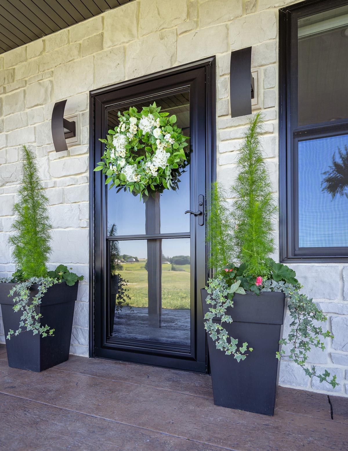 A black door with a wreath on top of it