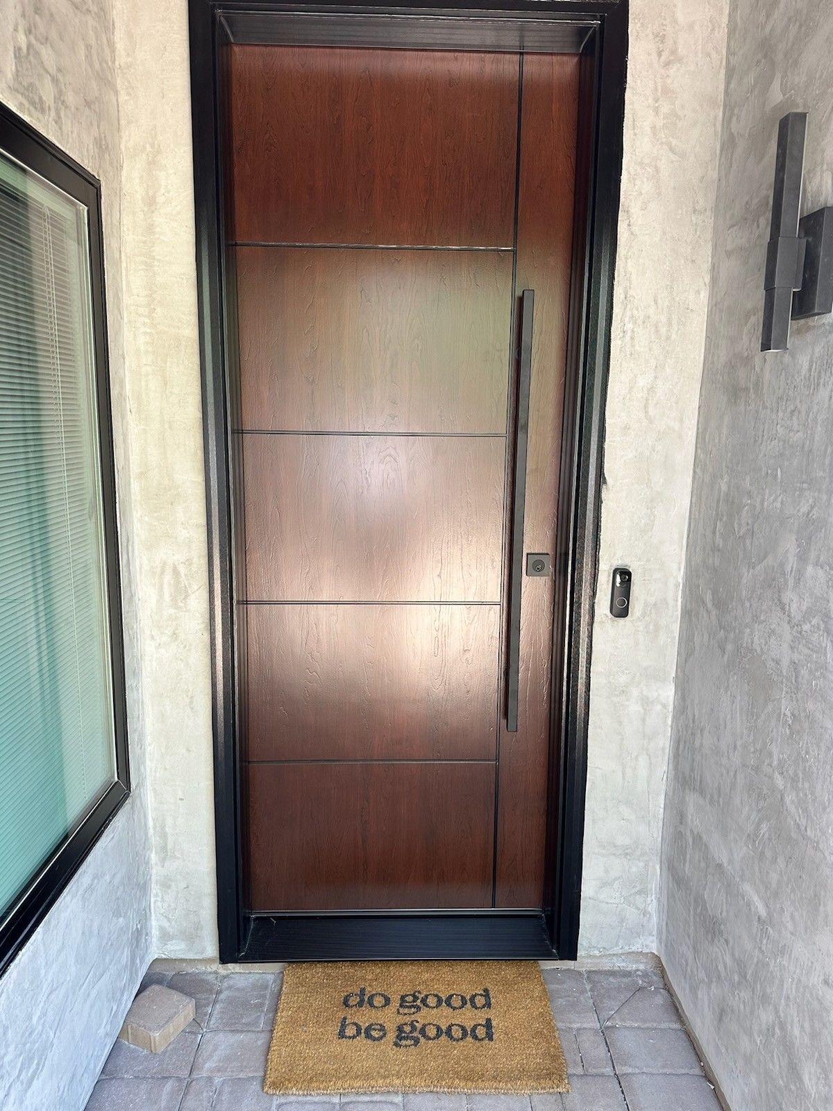 A wooden door with a welcome mat in front of it.