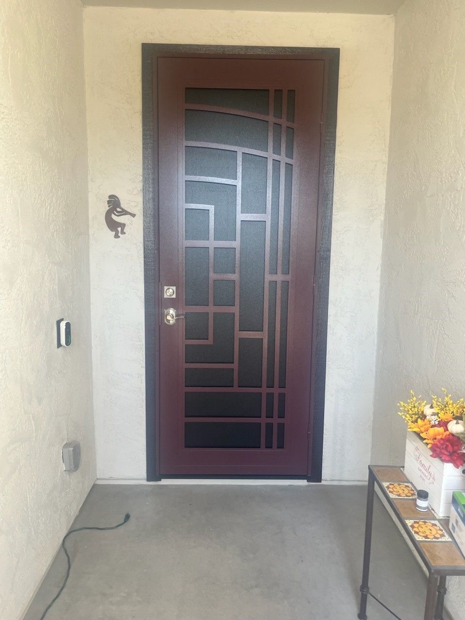 A door with a bird on it is in a room next to a table.