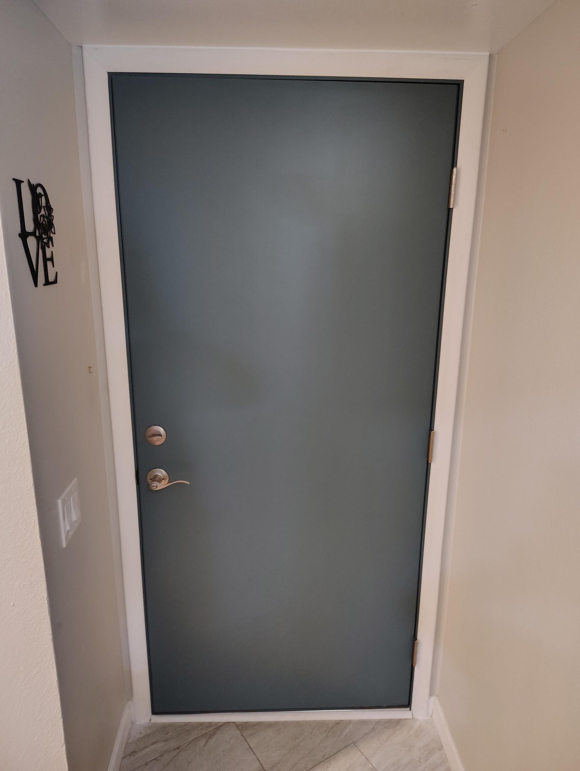 A blue door with a white trim is in a hallway