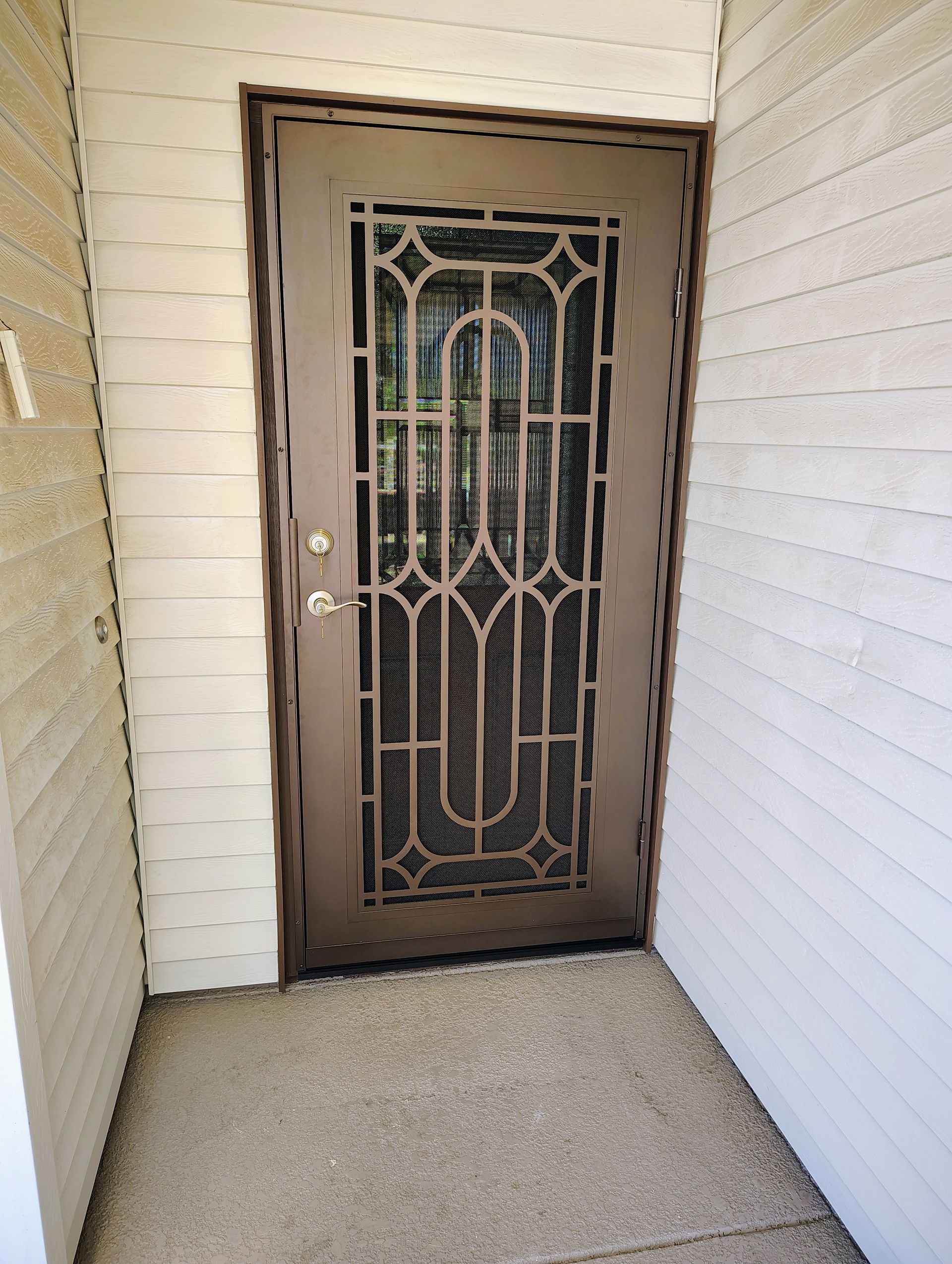 A door with a wrought iron design on it is in a hallway