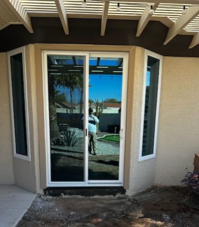A sliding glass door with a reflection of a person in it