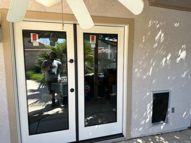 A glass door with a ceiling fan above it after