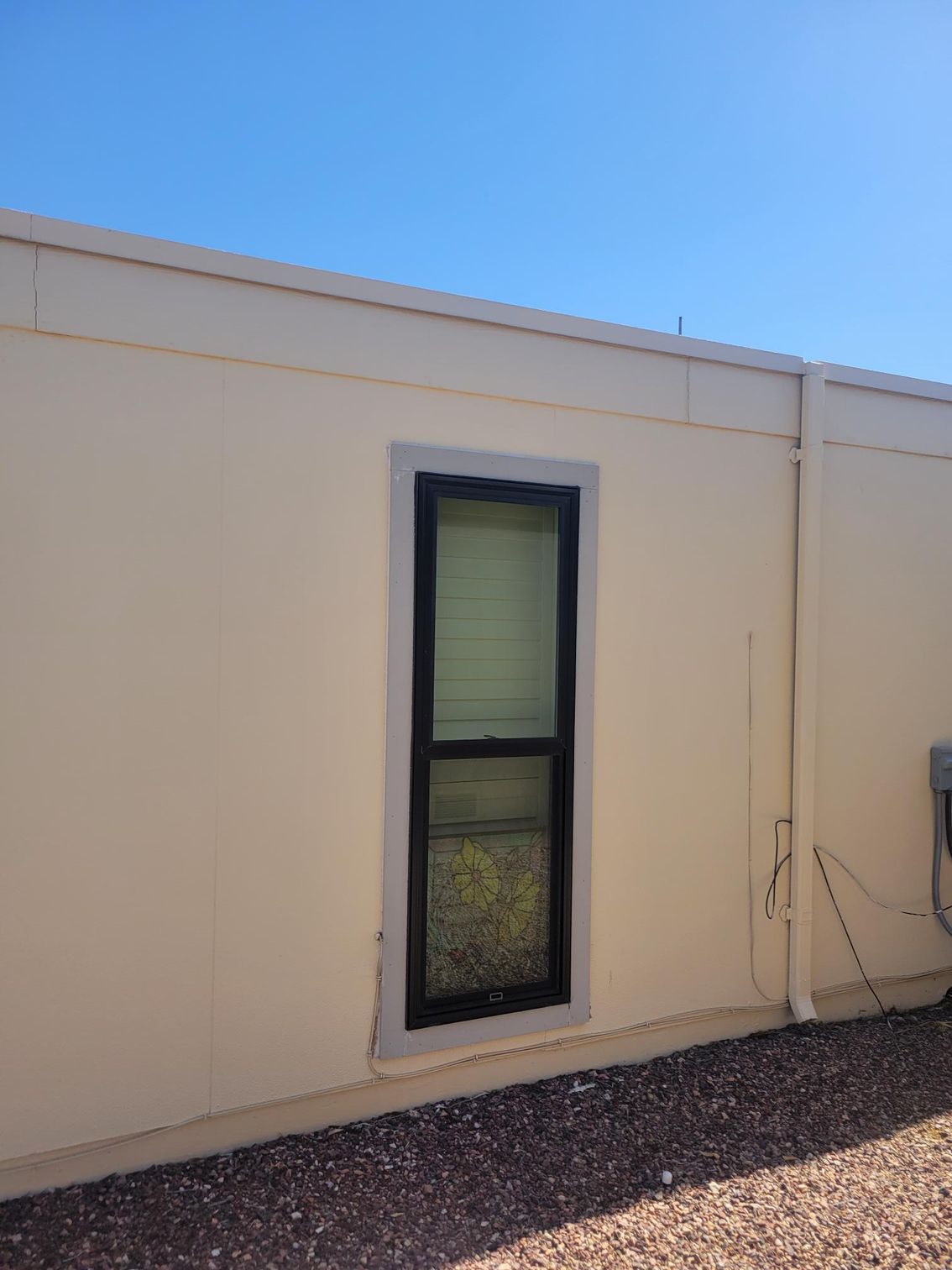 A white building with a window on the side of it