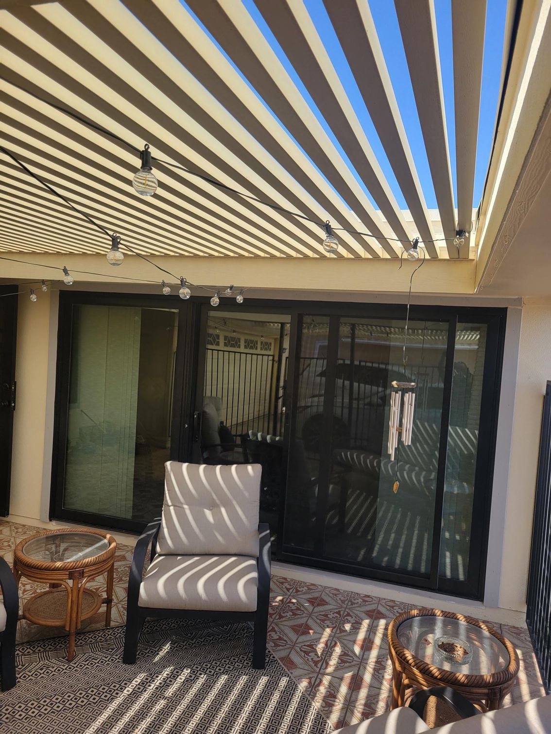 A patio with chairs, a table and a canopy over it