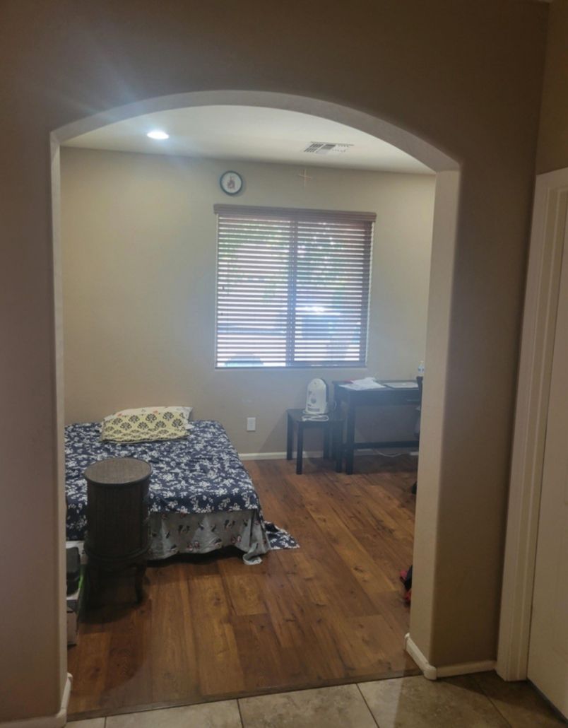 A bedroom with a bed , desk , and window.