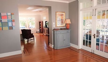 Interior view of a home with hardwood floors, a gray cabinet, and French doors leading to a patio.