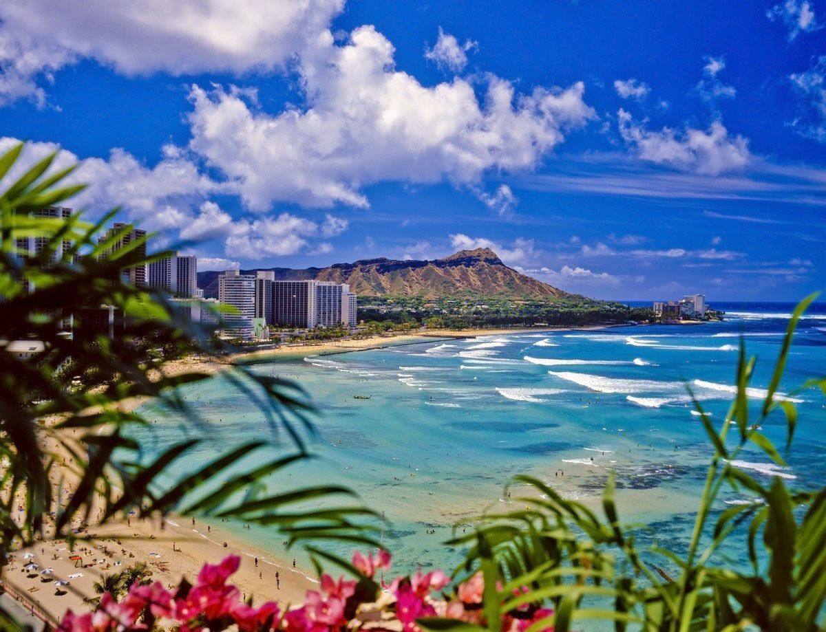 Beach scene with hotels, turquoise water, and people swimming