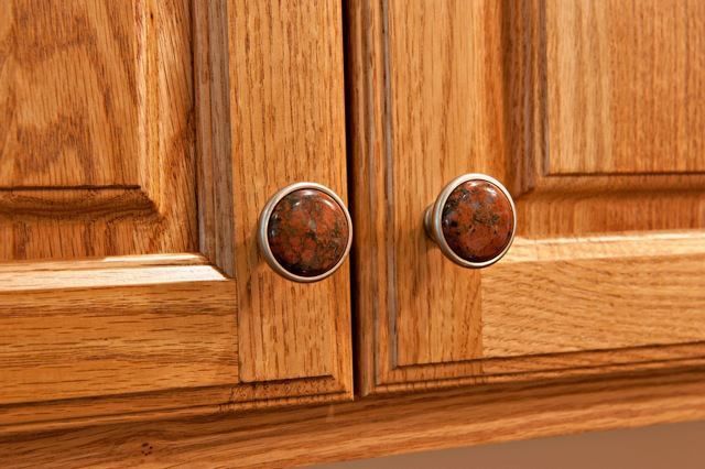 A close up of a wooden cabinet with two knobs on it.