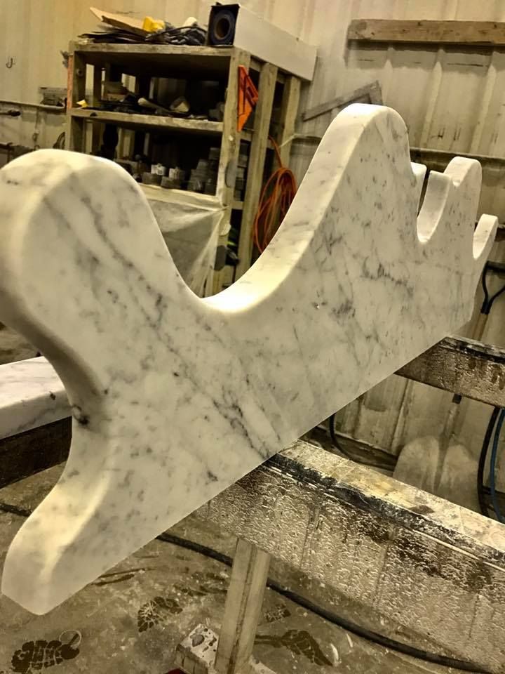 A large piece of marble is sitting on top of a wooden table.