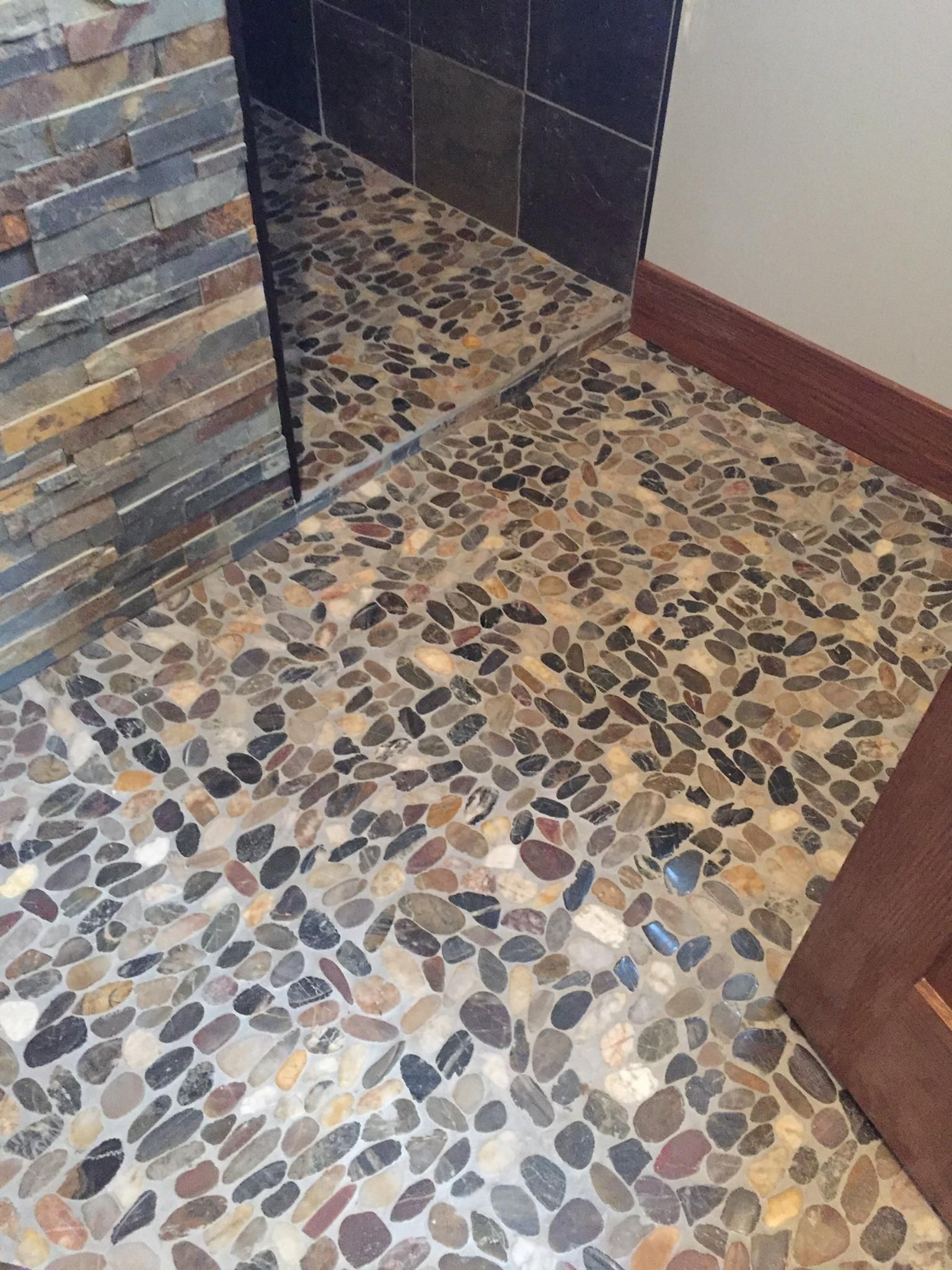 A bathroom with a tiled floor and a mirror.