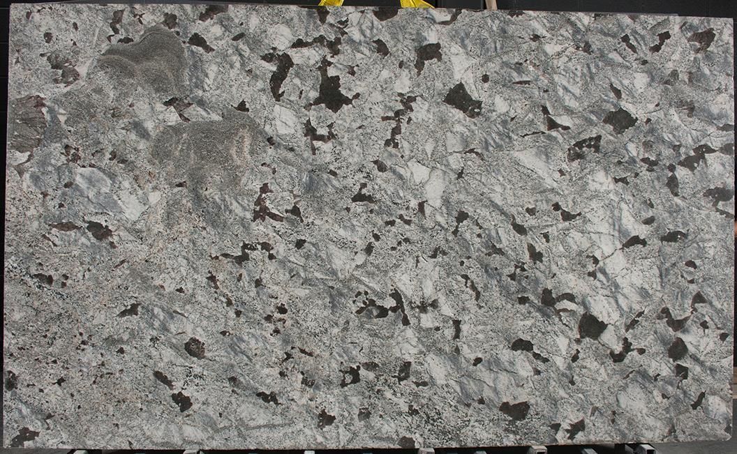 A close up of a granite slab with a gray and white marble texture.