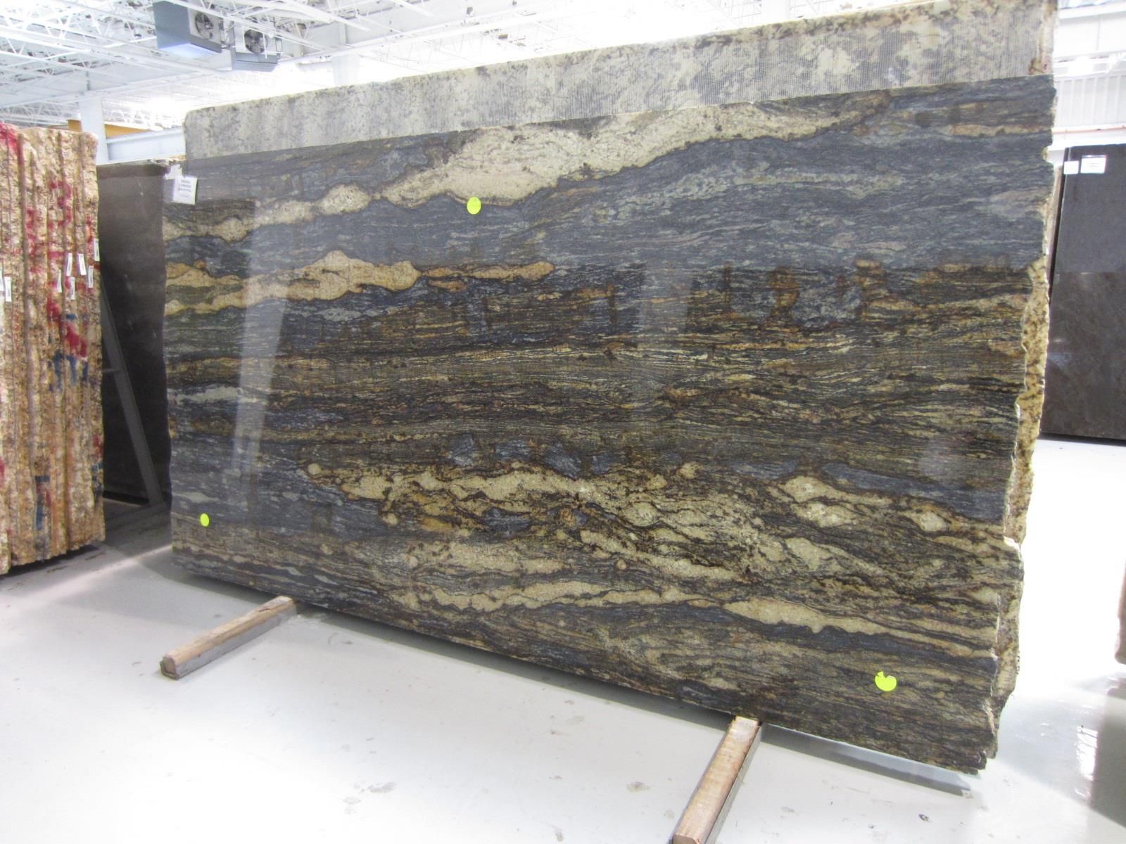 A large slab of granite is sitting on a wooden stand in a warehouse.