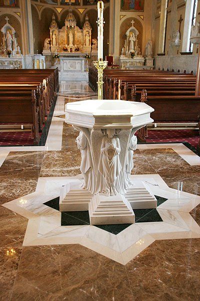 A baptismal font is sitting in the middle of a church.