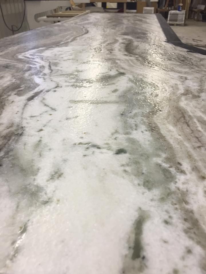 A close up of a marble counter top in a kitchen.