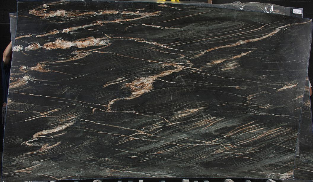 A close up of a black granite slab on a table.
