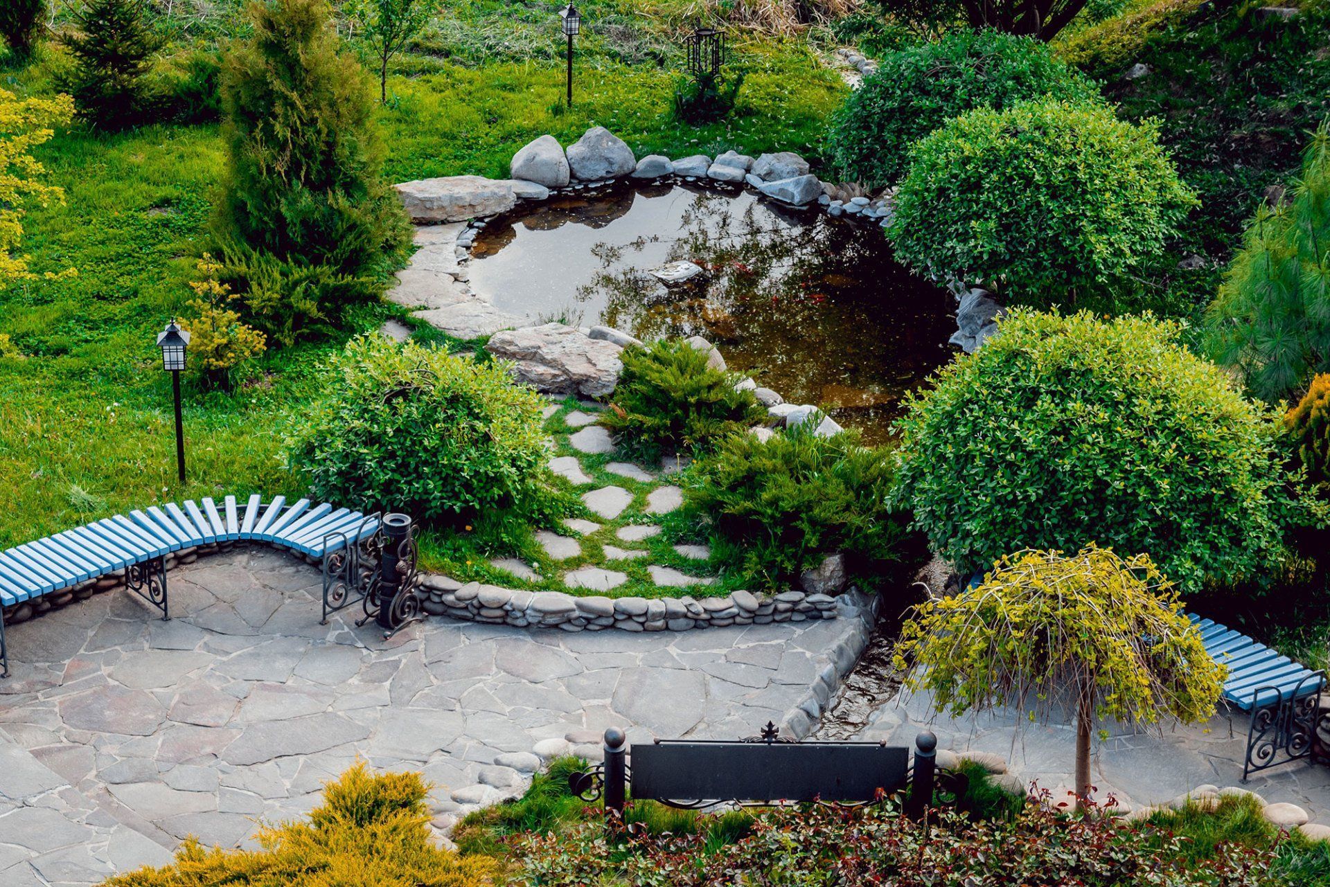 A park with a bench and a pond in the middle