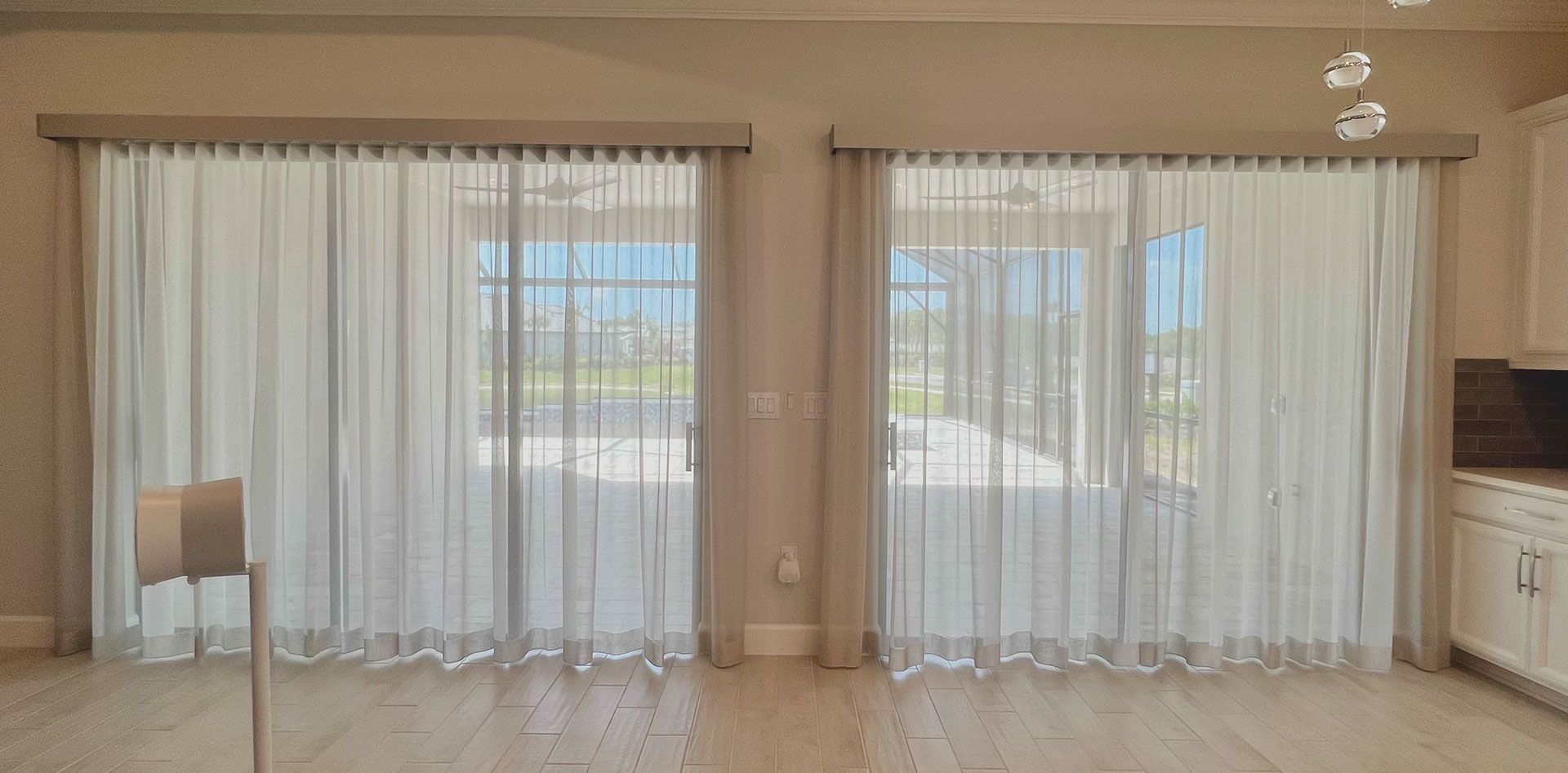 A living room with sliding glass doors and white curtains