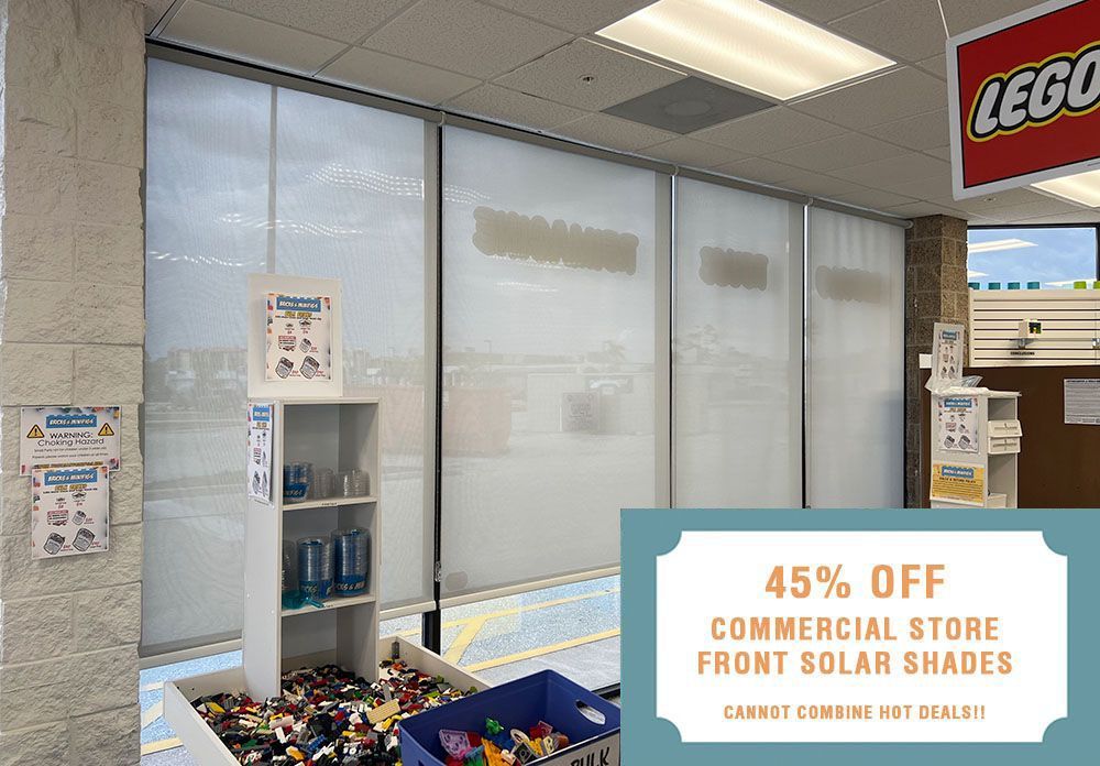 A picture of a window with a sign that says 45% off commercial store front solar shades