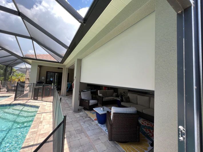 A patio with a swimming pool in the background