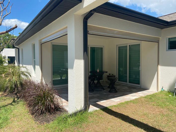 A white house with a patio and sliding glass doors.