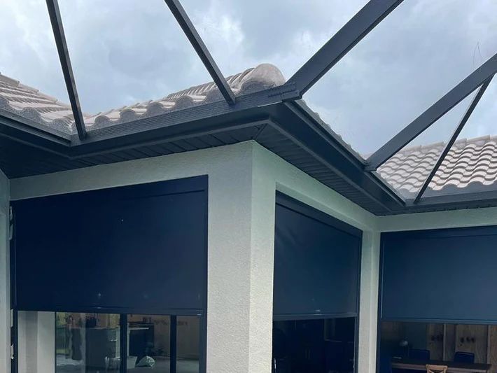 A house with a clear roof and black blinds on the windows.
