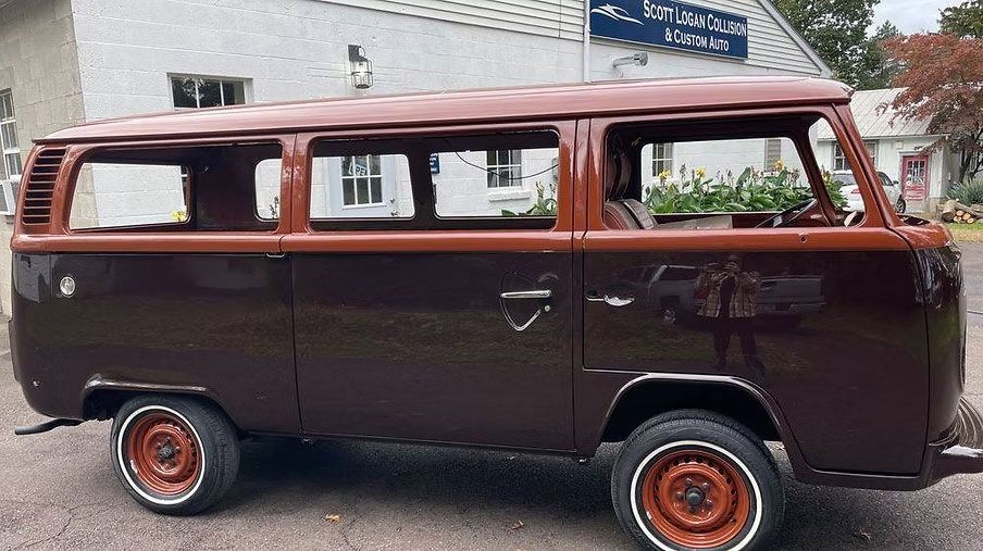 Brown and maroon vintage Volkswagen bus parked outdoors.