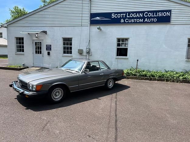 Gray Mercedes-Benz coupe parked outside Scott Logan Collision & Custom Auto shop.